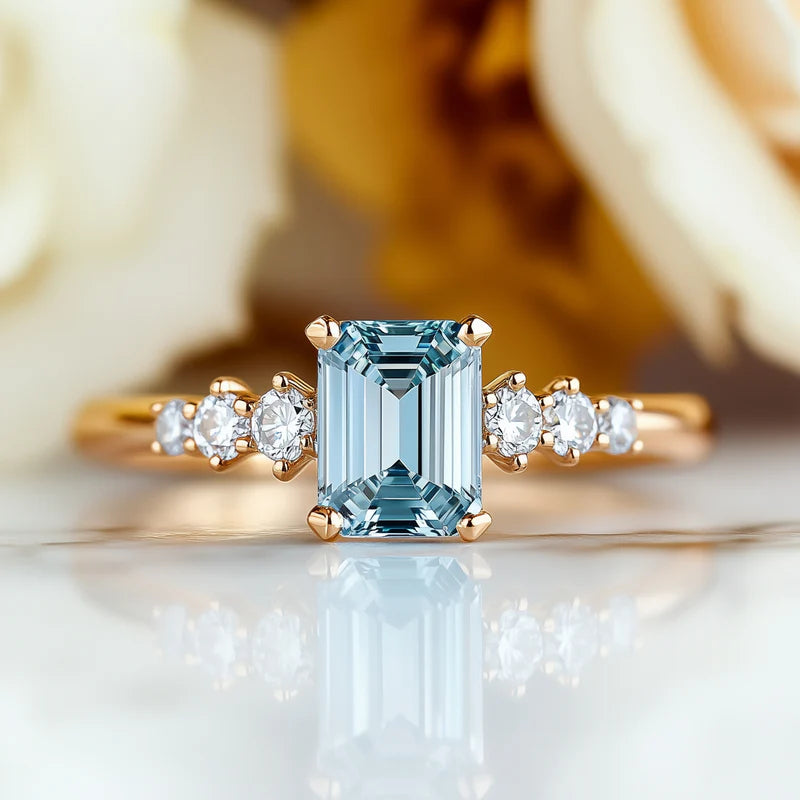 Image of an emerald cut moissanite ring featuring a beautiul 1CT blue moissanite stone in a frontal view in a very beautiful presentation and setting